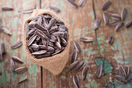 sunflower seeds on the wooden table (Helianthus annuus)の写真素材