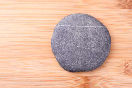circular and flat stone on woodの写真素材