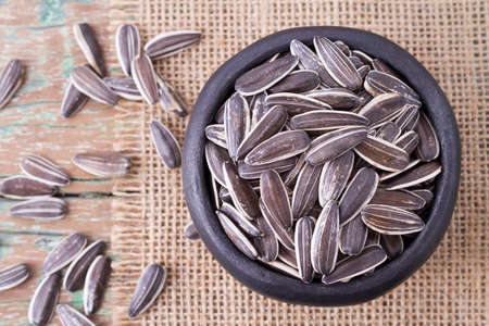 sunflower seeds on the wooden table (Helianthus annuus)の写真素材