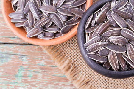 sunflower seeds on the wooden table (Helianthus annuus)の写真素材