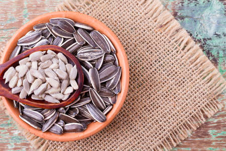 sunflower seeds on the wooden table (Helianthus annuus)の写真素材
