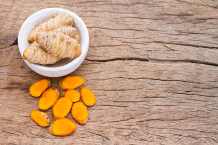 powder and roots of turmeric on wood - curcuma longaの写真素材