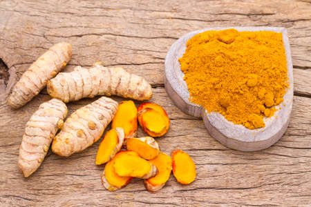 powder and roots of turmeric on wood - curcuma longaの写真素材