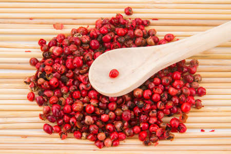 red peppercorns, on chopping board.の写真素材