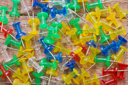 thumbtacks of colors on old wood top viewの写真素材