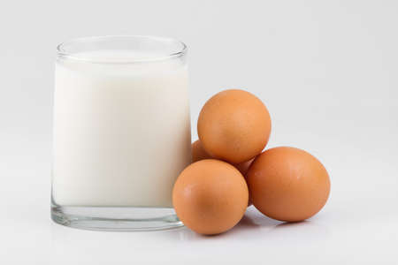 glass with milk and eggs isolated on white background.の写真素材