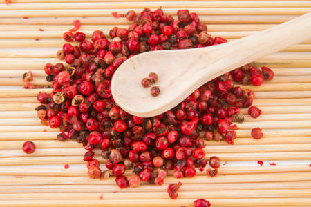 red peppercorns, on chopping board.の写真素材