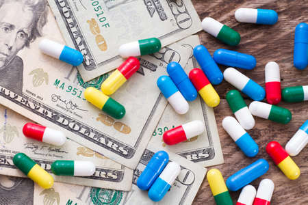 dollar bills and medicine capsules, medicine purchase concept.の写真素材