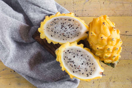 yellow pitahaya dragon fruit on wooden backgroundの写真素材