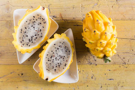 yellow pitahaya dragon fruit on wooden backgroundの写真素材