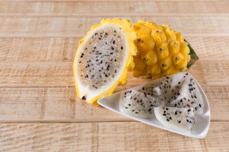 yellow pitahaya dragon fruit on wooden backgroundの写真素材