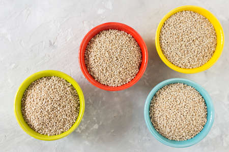 organic quinua cereal in color bowl on white backgroundの写真素材