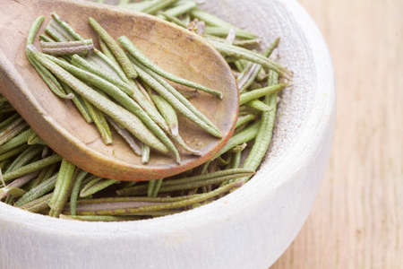dried rosemary in bowl on the table closeup view.の写真素材