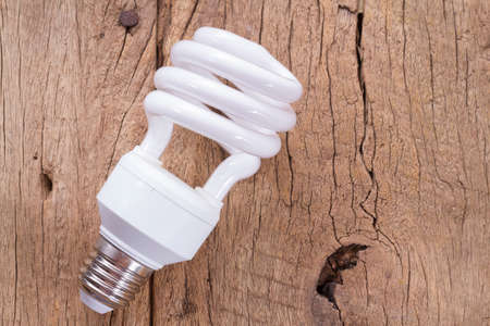 Fluorescent light bulb on wooden backgroundの写真素材