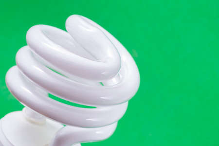 Fluorescent light bulb on green background, technology that contains polluting gasesの写真素材