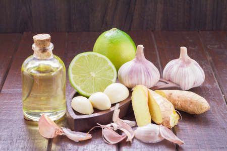 garlic, lemon and vegetable oil on the tableの写真素材