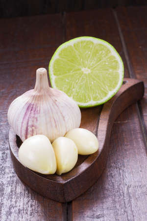 garlic and lemon in bowl on wooden table.の写真素材