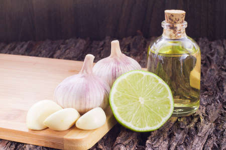 garlic, lemon and vegetable oil on the tableの写真素材