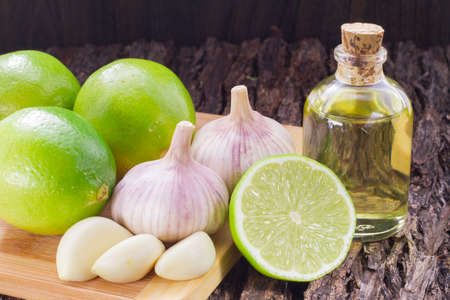 garlic, lemon and vegetable oil on the tableの写真素材