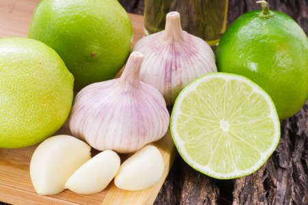 garlic and lemon in bowl on wooden table.の写真素材
