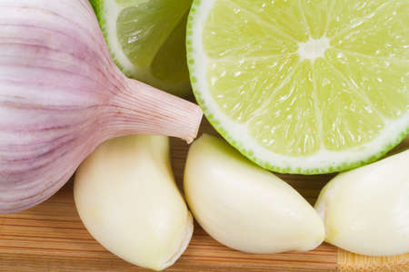 garlic and lemon in bowl on wooden table.の写真素材