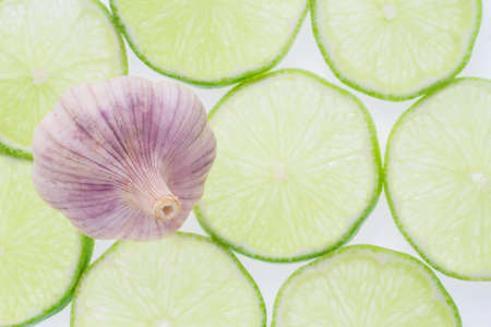 garlic and slices of lemon on white background.の写真素材