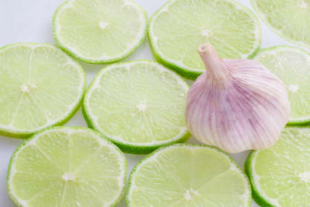 garlic and slices of lemon on white background.の写真素材