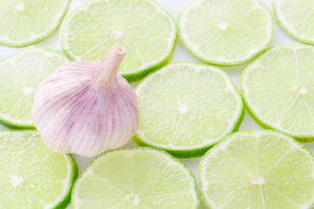 garlic and slices of lemon on white background.の写真素材