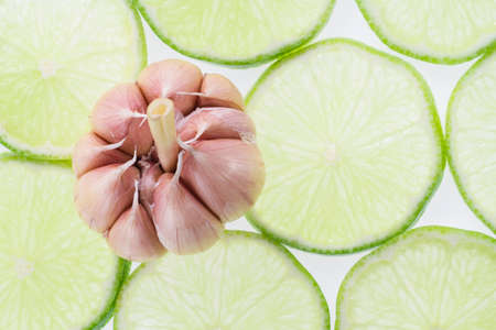 garlic and slices of lemon on white background.の写真素材