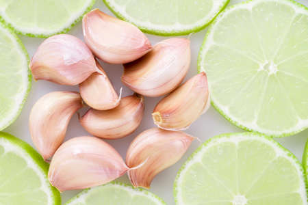 garlic and slices of lemon on white background.の写真素材