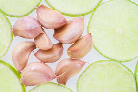 garlic and slices of lemon on white background.の写真素材