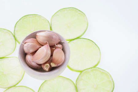 garlic and slices of lemon on white background.の写真素材