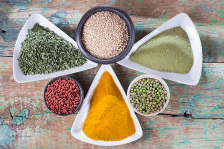 collection of super foods in several containers arranged randomly on the tableの写真素材