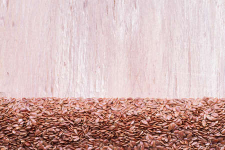 linseed seeds in container and spoon on the table.の写真素材