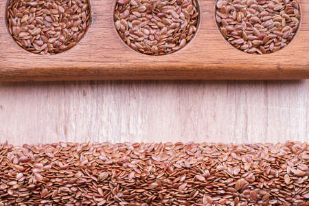 linseed seeds in container and spoon on the table.の写真素材
