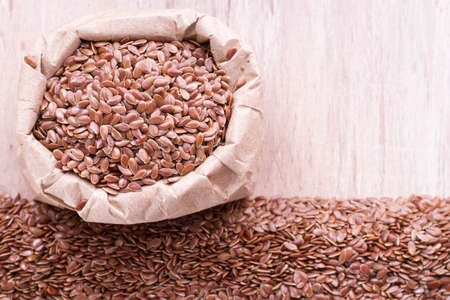 linseed seeds in container and spoon on the table.の写真素材