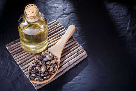 beans and castor oil on the black tableの写真素材