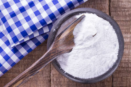 baking soda in bowl on wooden tableの写真素材
