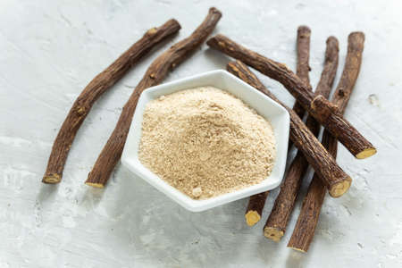 Powder and licorice root on the table - Glycyrrhiza glabra.の写真素材