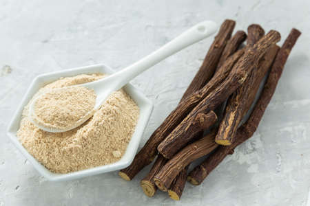 Powder and licorice root on the table - Glycyrrhiza glabra.の写真素材