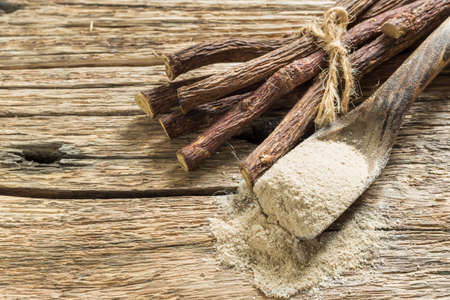 Powder and licorice root on the table - Glycyrrhiza glabra.の写真素材