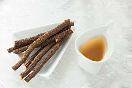 Licorice tea and roots on white backgroundの写真素材