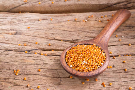 red millet in bowl on rustic wooden background.の写真素材