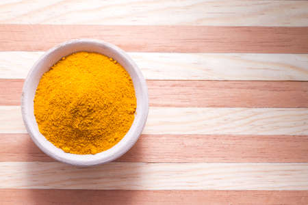 Turmeric powder on wooden background - curcuma longaの写真素材