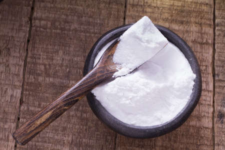 baking soda in bowl on wooden tableの写真素材