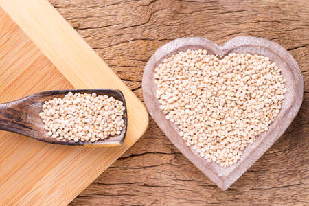 Quinoa seeds in bowl on rustic wood.の写真素材
