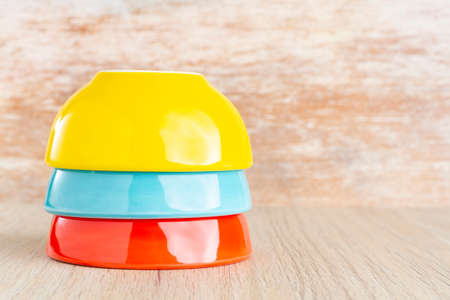 Ceramic bowl assorted colors on wooden background, close-upの写真素材