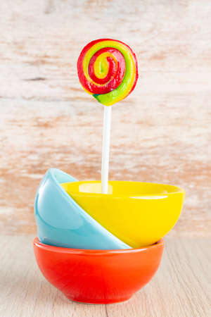 lollipops and colorful pots on wooden background, close-upの写真素材