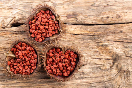 Annatto seeds on rustic wood, top viewの写真素材