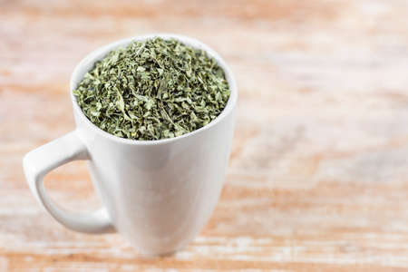 white cup with moringa leaves on wooden backgroundの写真素材